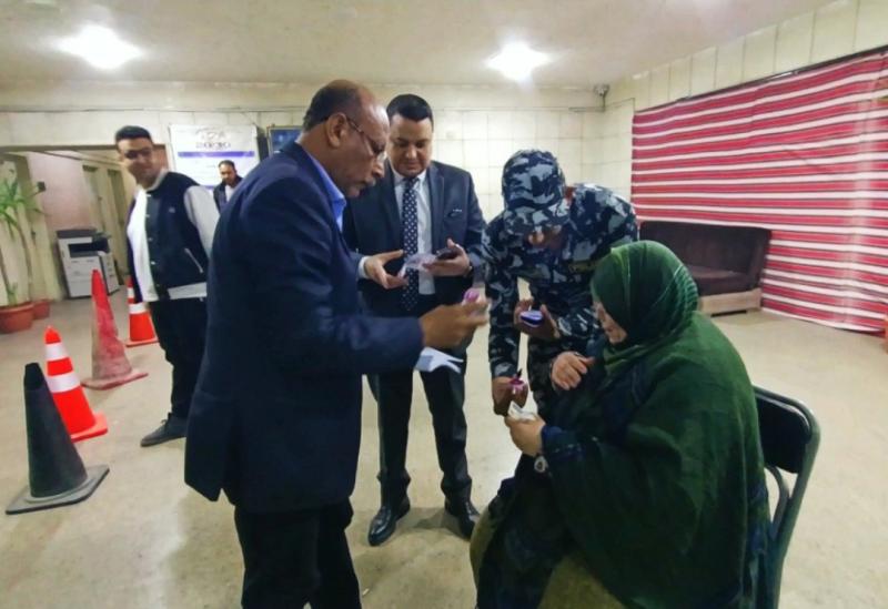 رئيس لجنة بالإسكندرية يساعد مسنه للإدلاء بصوتها فى انتخابات الرئاسة