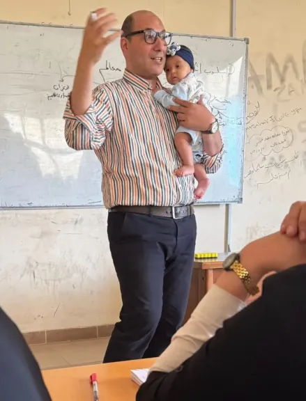في مشهد إنساني مؤثر.. عميد كلية التجارة بجامعة كفر الشيخ يحمل رضيعة طالبة أثناء المحاضرة ويكمل الشرح مبتسمًا