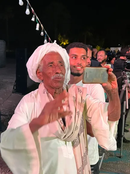 ماسك التليفون وبيصور.. صعيدي مُسن يخطف الأنظار بفرحته بأغاني فاطمة عيد في مهرجان قنا بمعبد دندرة