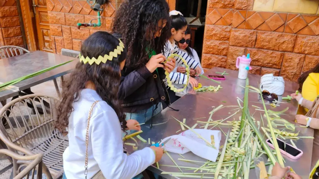 تيجان وصلبان من السعف والزيّ الملوكي.. بهجة أحد الشعانين تزين كنيسة الأنبا بيشوي ببورسعيد